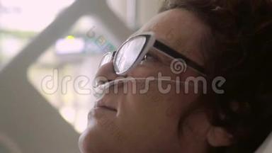 一位戴眼镜的老年妇女被关在一张病床上，上面滴着氧气罩。 4k